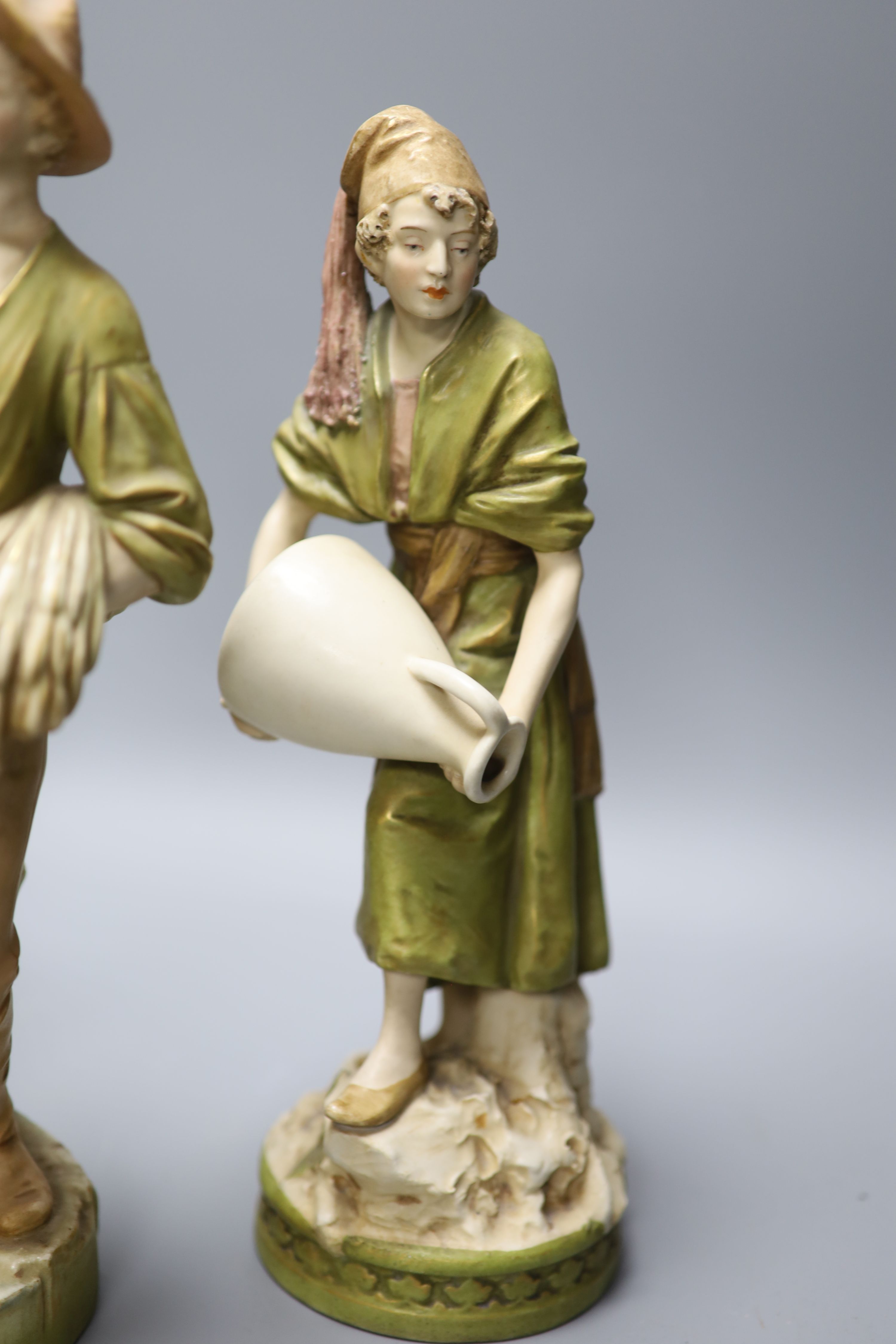 A pair of Royal Dux female water carriers and another of a farmer, 32cm